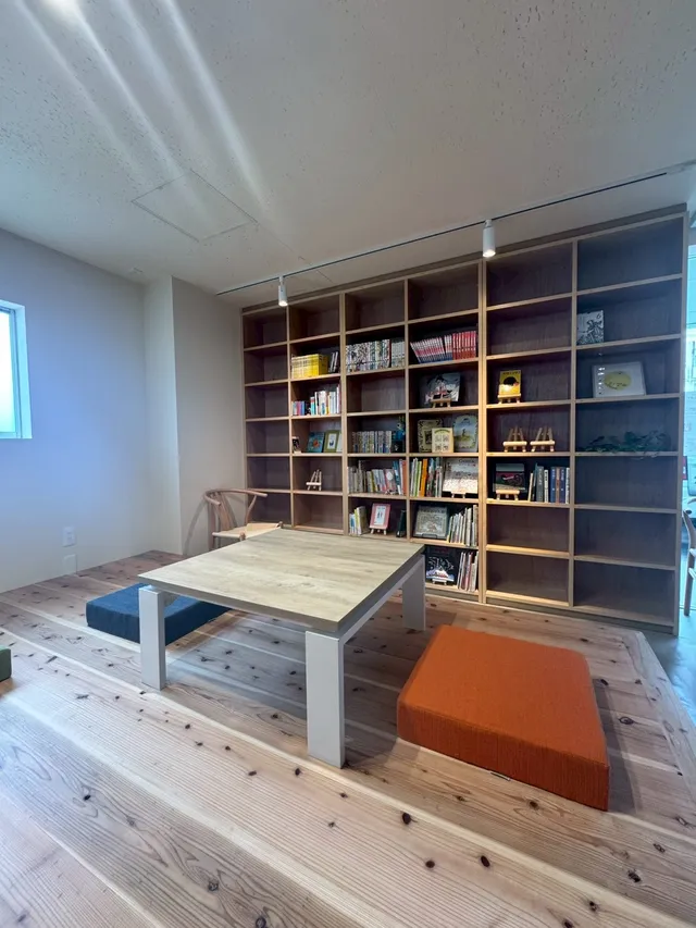 木の小上がりと本棚のある店内